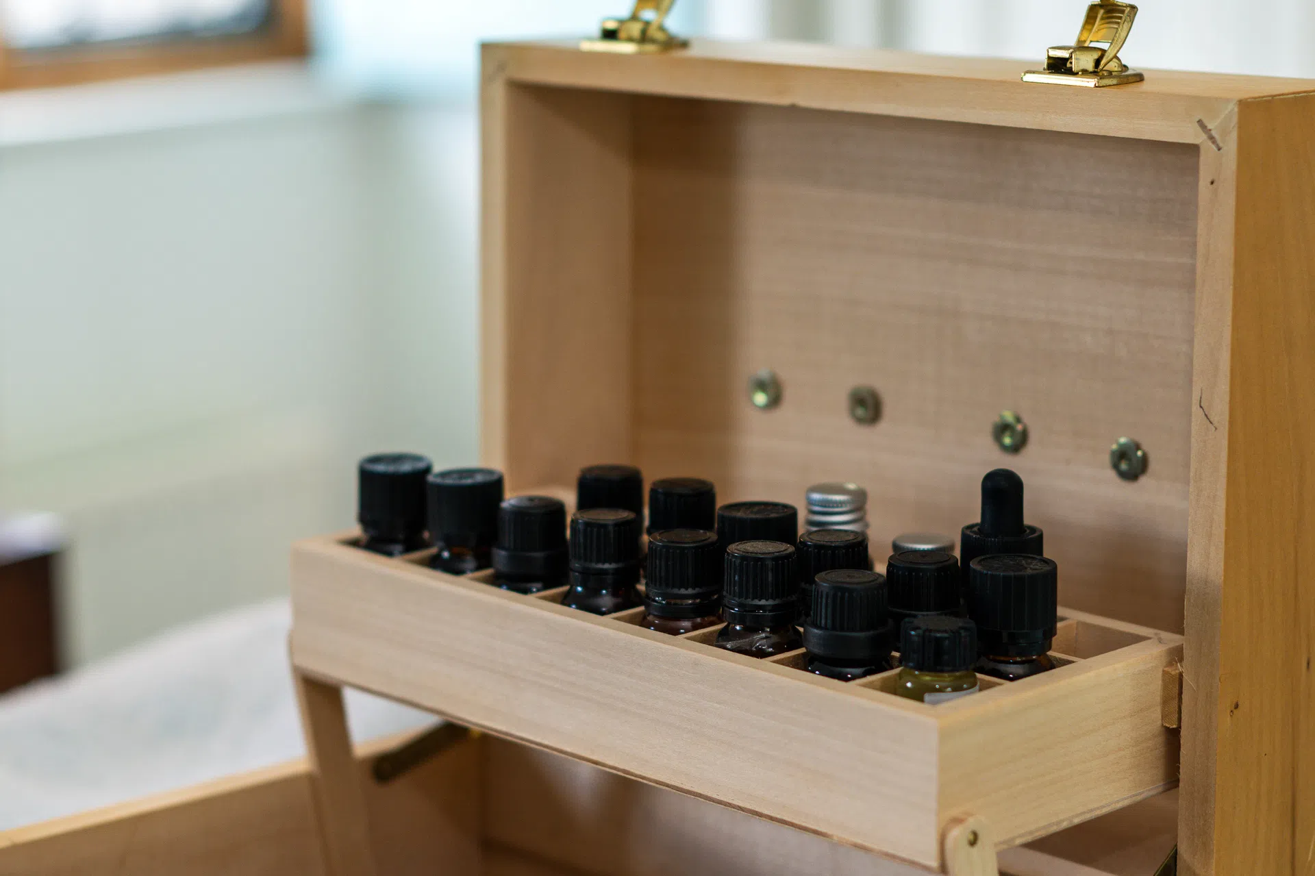 A wooden storage case filled with essential oil bottles.