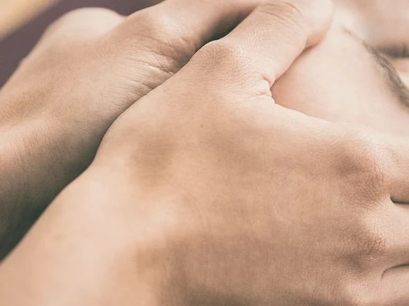 A close-up of hands massaging a person's scalp.