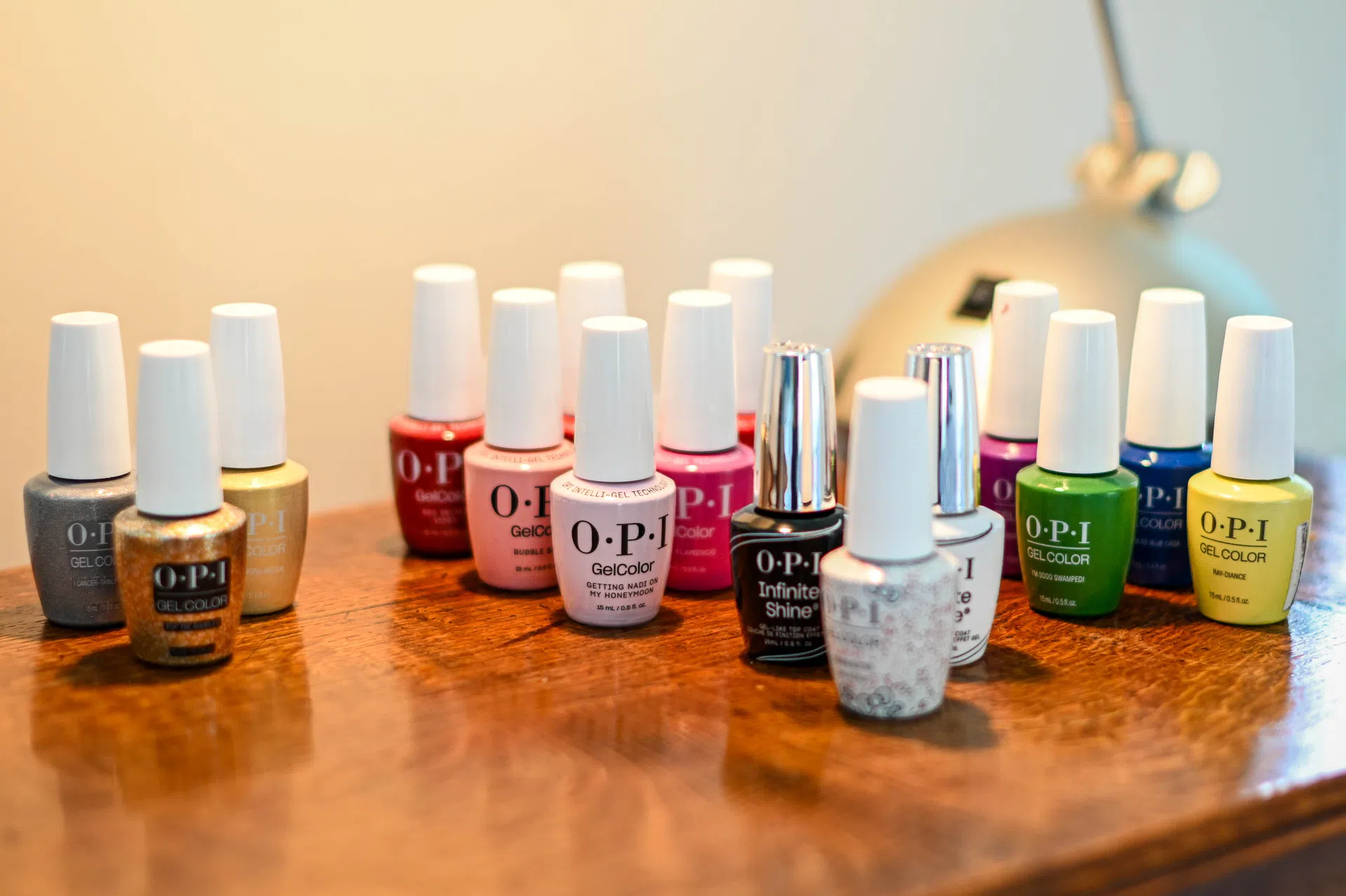 A selection of OPI nail polish colours arranged on a wooden table.