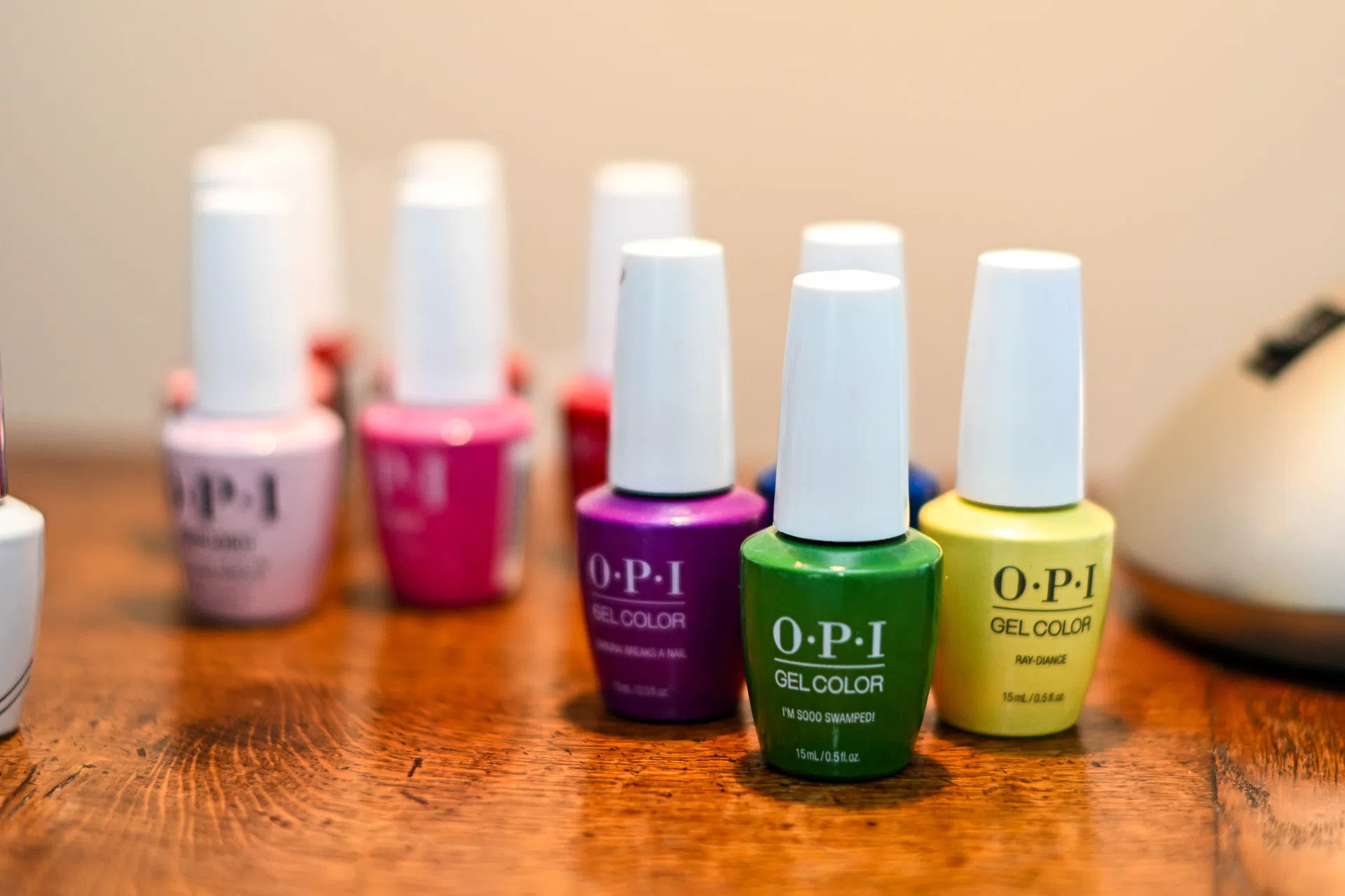 Green, yellow and purple nail polish bottles for nail treatments.